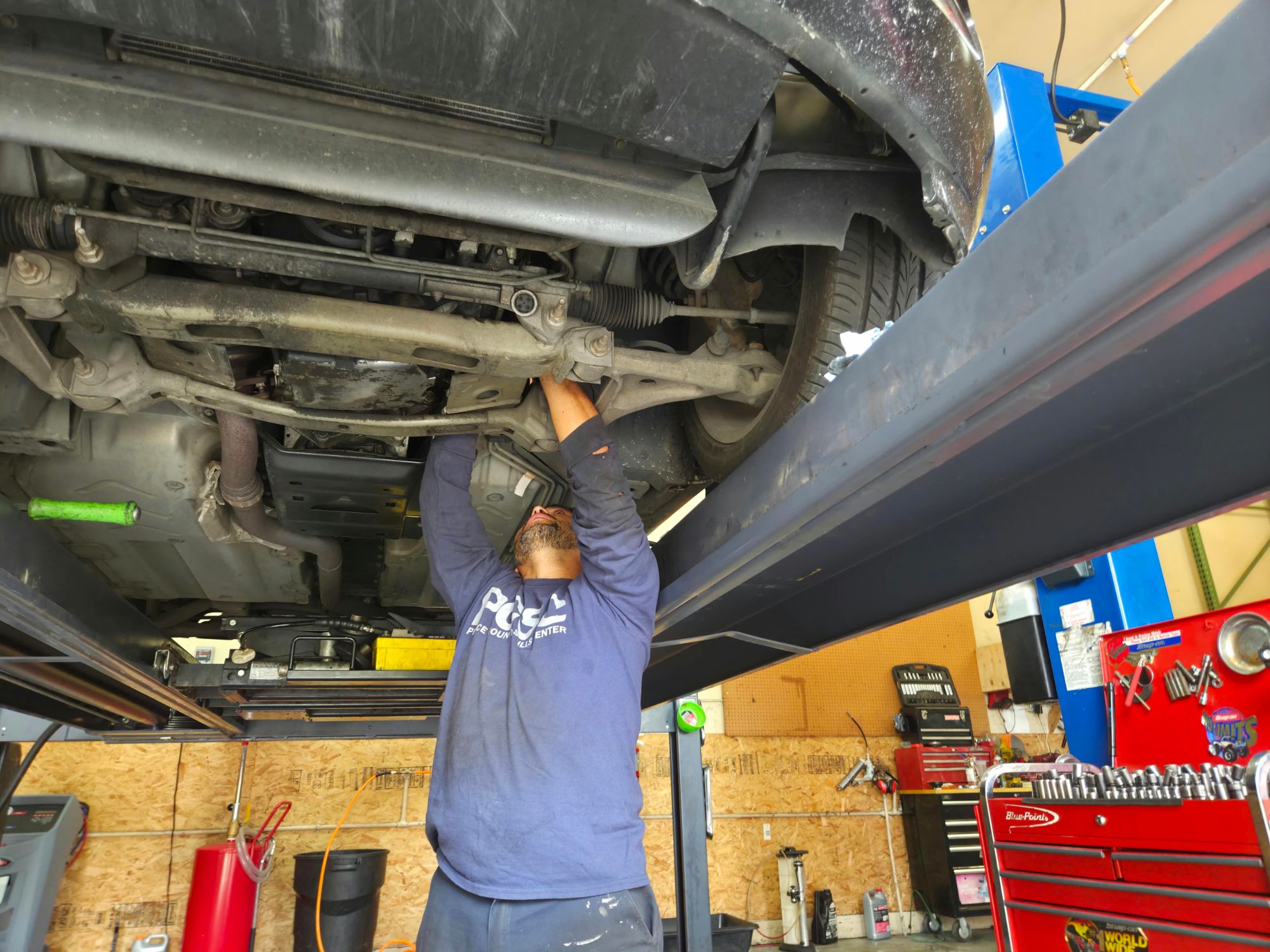 Technician working under a vehicle on the lift