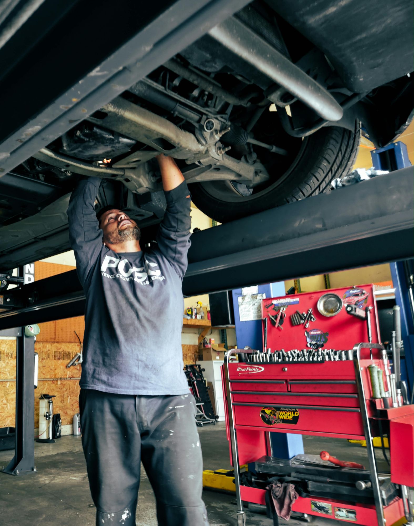 Auto Star technician inspecting a vehicle from below