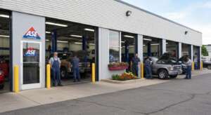 Auto repair shop exterior with ASE-certified mechanics working on vehicles, showcasing trust and professionalism
